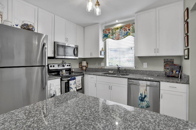 kitchen with appliances with stainless steel finishes, a sink, and white cabinetry