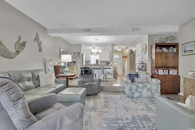 living area featuring a chandelier and light wood-style floors