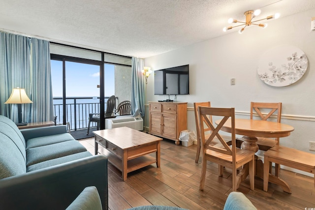 6804 N Ocean Blvd Unit 829, Myrtle Beach, SC 29572 - living room with a textured ceiling, a wall of windows, a chandelier, and wood finished floors