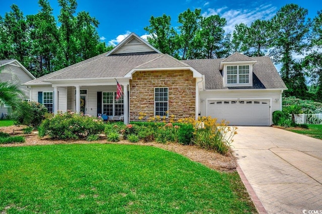 100 Woodlyn Ave, Little River, SC 29566 - view of front of home with a front yard, driveway, stone siding, and an attached garage