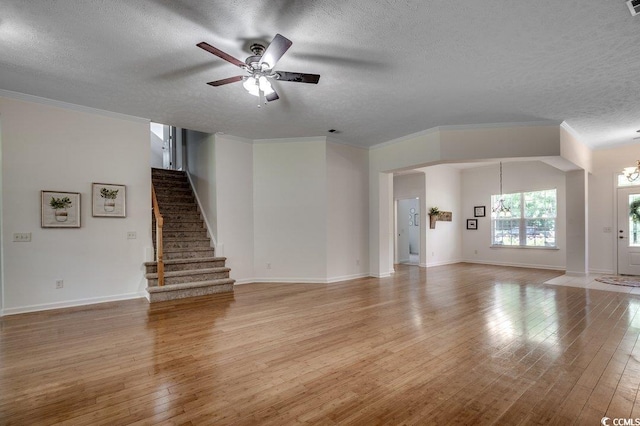 100 Woodlyn Ave, Little River, SC 29566 - unfurnished living room with a textured ceiling, a chandelier, light wood-type flooring, a ceiling fan, and stairway
