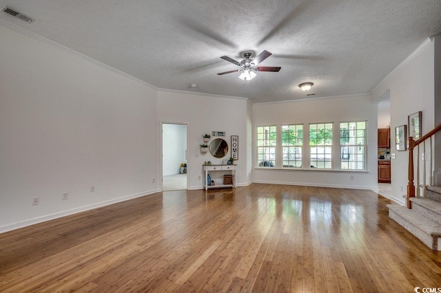100 Woodlyn Ave, Little River, SC 29566 - unfurnished living room with stairway, a ceiling fan, wood-type flooring, a textured ceiling, and ornamental molding