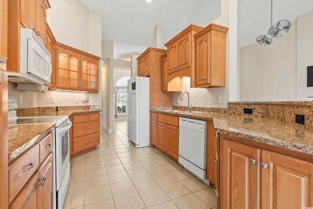 8204 Caddis Ct, Myrtle Beach, SC 29579 - kitchen with white appliances, light tile patterned floors, brown cabinets, and light stone counters