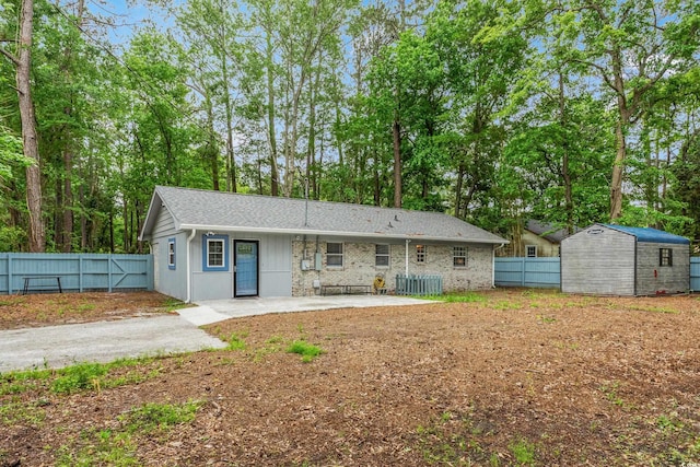 1111 King St, Myrtle Beach, SC 29577 - back of house with a storage unit, a fenced backyard, a patio, and view of scattered trees