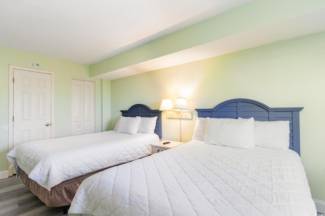 bedroom featuring wood finished floors, baseboards, and a closet