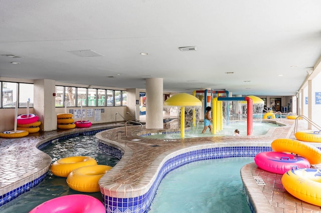 indoor community pool with a hot tub