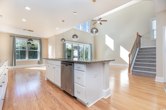 kitchen featuring stainless steel dishwasher, a sink, light wood-style floors, healthy amount of natural light, and recessed lighting