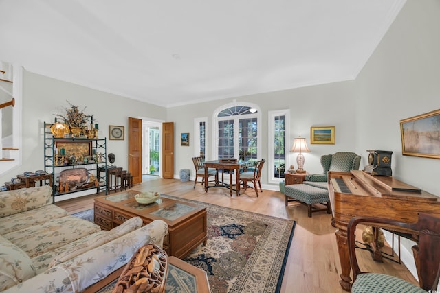 living area featuring light wood-type flooring and ornamental molding