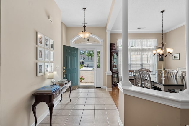 190 Barony Pl, Pawleys Island, SC 29585 - entrance foyer featuring a chandelier, light tile patterned floors, decorative columns, crown molding, and baseboards