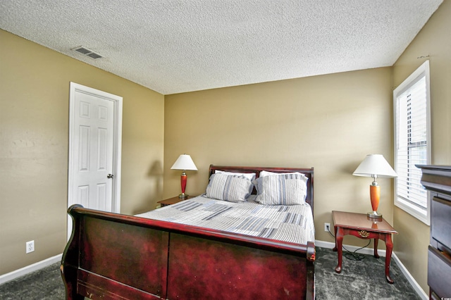 carpeted bedroom with a textured ceiling and baseboards