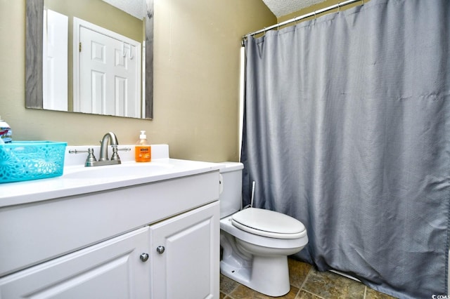 full bathroom with toilet, vanity, a textured ceiling, stone finish flooring, and a shower with shower curtain
