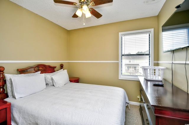 bedroom featuring carpet floors, baseboards, ceiling fan, and a textured ceiling