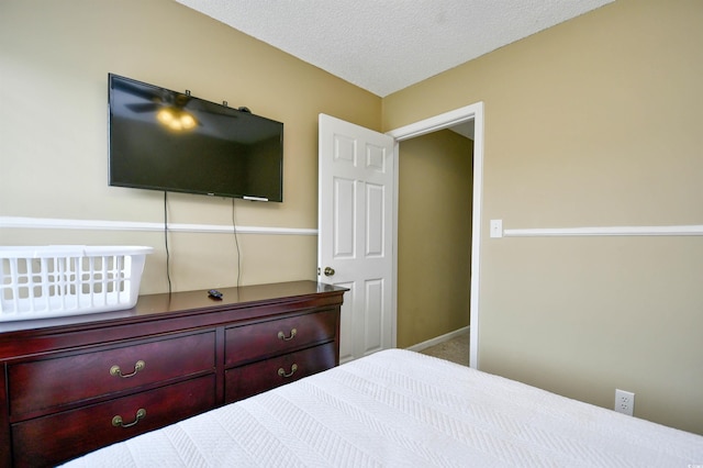 carpeted bedroom with a textured ceiling and baseboards