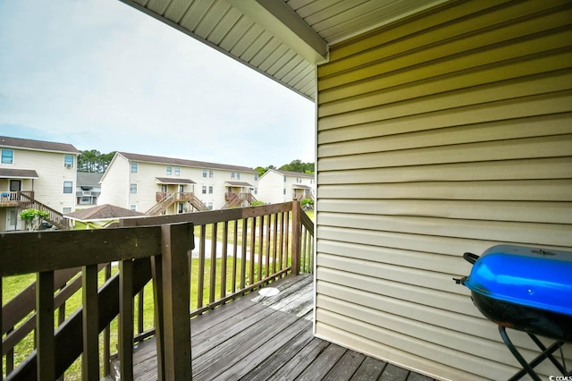 wooden deck featuring a grill and a residential view