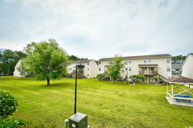 view of grassy yard with stairway and a residential view