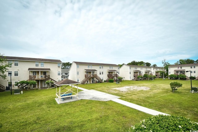 rear view of property with a residential view, stairs, and a yard