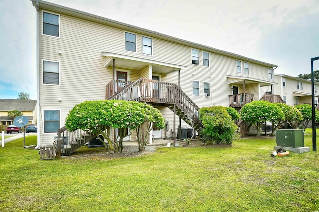 back of property featuring stairway, a lawn, central air condition unit, and a wooden deck