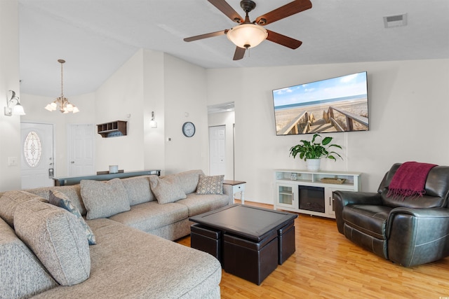 living room featuring light wood-style floors, a chandelier, ceiling fan, and high vaulted ceiling