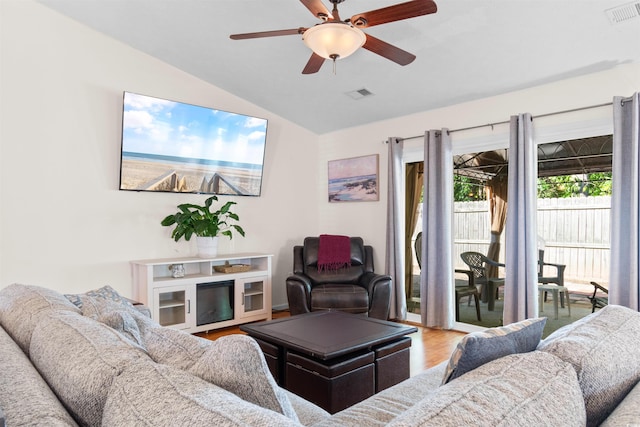 living area featuring lofted ceiling, wood finished floors, and a ceiling fan