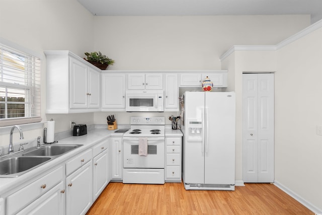 kitchen featuring white appliances, a sink, white cabinets, light countertops, and light wood finished floors