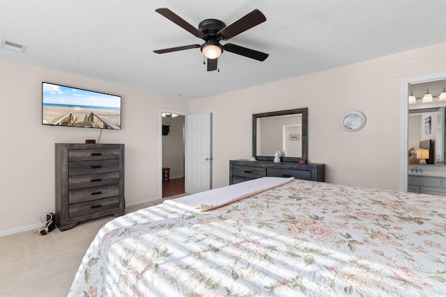 bedroom with light carpet, ensuite bath, baseboards, and ceiling fan