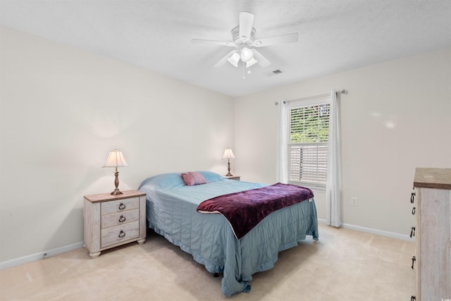bedroom with light carpet, baseboards, and a ceiling fan