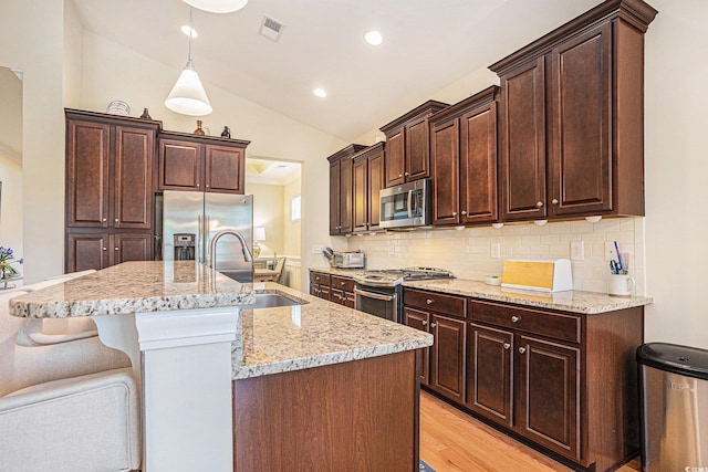 967 Henry James Dr, Myrtle Beach, SC 29579 - kitchen featuring appliances with stainless steel finishes, a sink, vaulted ceiling, decorative backsplash, and dark brown cabinets