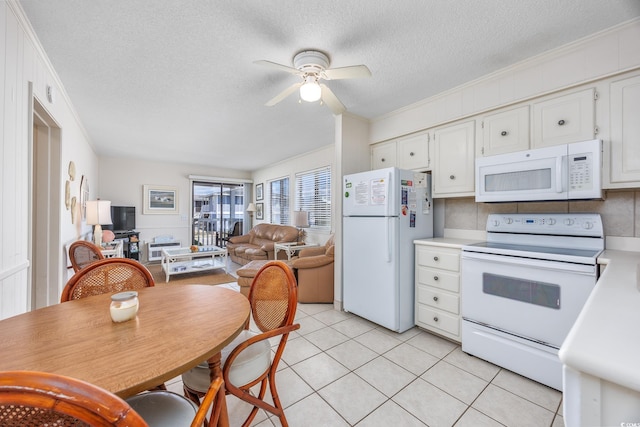 kitchen with white appliances, ceiling fan, light countertops, ornamental molding, and white cabinets