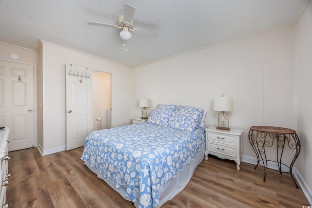 bedroom featuring wood finished floors, ornamental molding, ceiling fan, and baseboards
