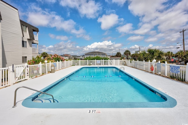 community pool with fence and a patio area