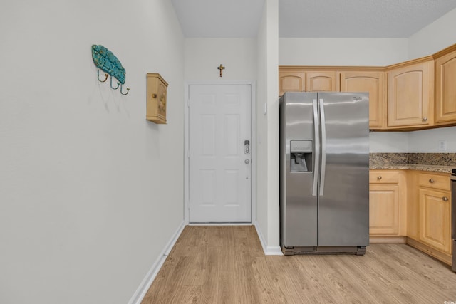 kitchen featuring stainless steel refrigerator with ice dispenser, light wood-style floors, light brown cabinets, and light stone counters
