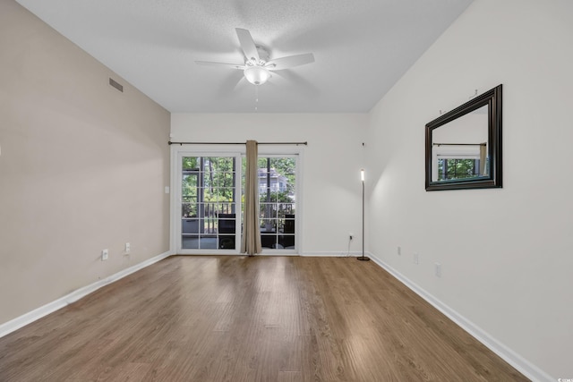 spare room featuring ceiling fan, baseboards, and wood finished floors