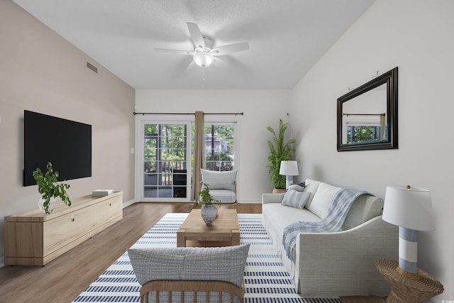 living area featuring a ceiling fan, wood finished floors, and baseboards