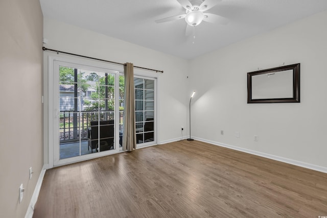 empty room with baseboards, wood finished floors, and ceiling fan