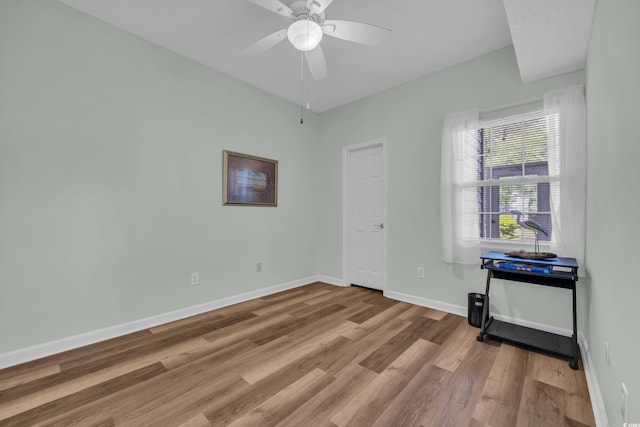unfurnished room featuring wood finished floors, baseboards, and a ceiling fan