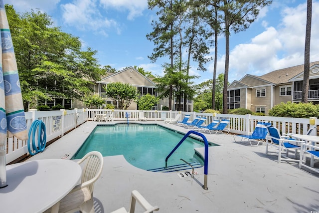 community pool featuring a patio area and fence