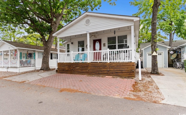 6001 S Kings Hwy, Myrtle Beach, SC 29575 - view of front facade featuring covered porch, concrete driveway, a garage, and an outdoor structure