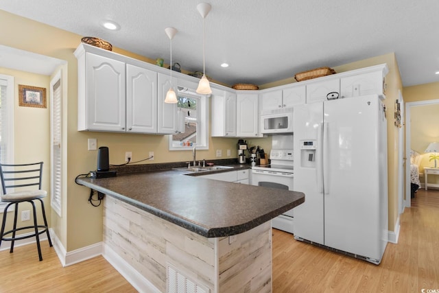 6001 S Kings Hwy, Myrtle Beach, SC 29575 - kitchen with white appliances, a sink, dark countertops, a peninsula, and white cabinets