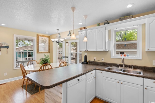 6001 S Kings Hwy, Myrtle Beach, SC 29575 - kitchen with a sink, dishwasher, dark countertops, a peninsula, and light wood-type flooring