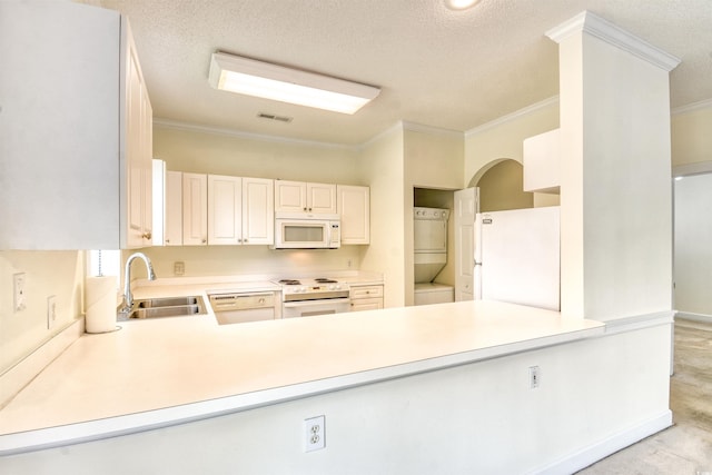 4683 Wild Iris Dr Unit 104, Myrtle Beach, SC 29577 - kitchen featuring white appliances, a sink, stacked washer / drying machine, ornamental molding, and light countertops