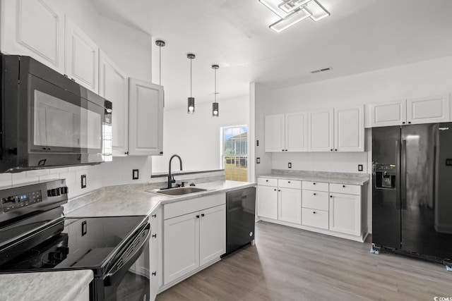 kitchen featuring black appliances, a sink, white cabinets, and tasteful backsplash