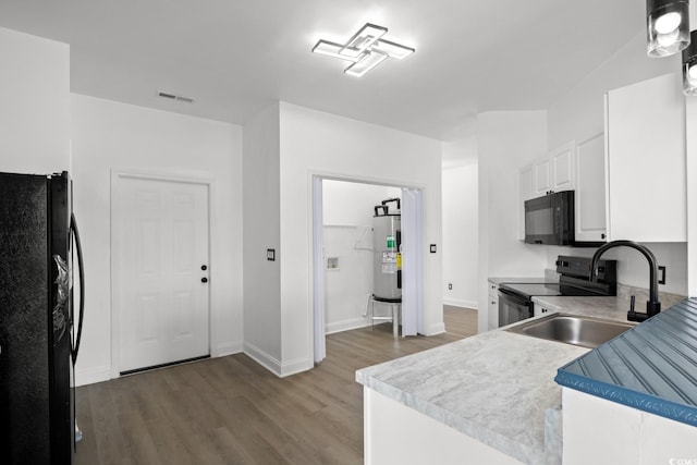 kitchen featuring black appliances, a sink, wood finished floors, electric water heater, and white cabinets