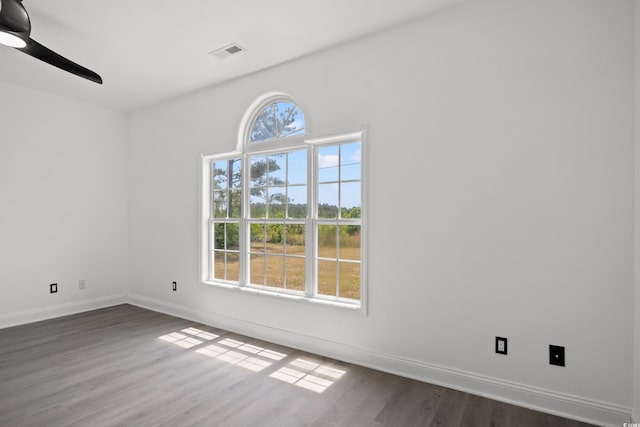 unfurnished room featuring dark wood-style flooring, baseboards, and ceiling fan