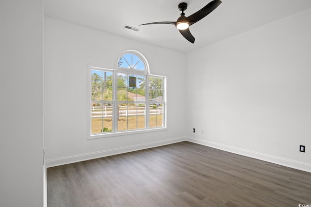 spare room with dark wood-style flooring, baseboards, and ceiling fan