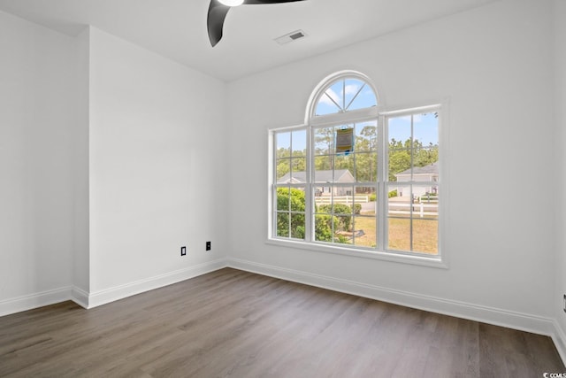 spare room with ceiling fan, baseboards, and dark wood-style flooring