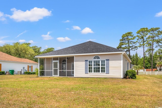 rear view of house featuring a shingled roof, a sunroom, and central air condition unit