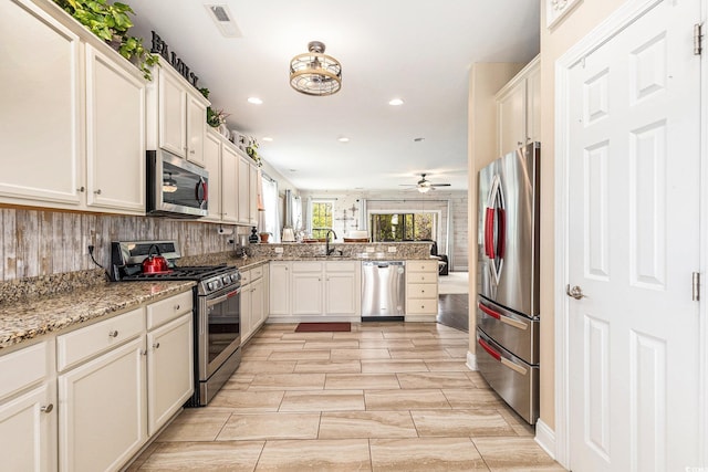 1367 Bermuda Grass Dr, Myrtle Beach, SC 29579 - kitchen featuring dishwasher, a sink, ceiling fan, light stone countertops, and light wood-style flooring