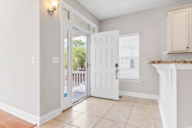 entrance foyer featuring plenty of natural light, baseboards, and light tile patterned floors