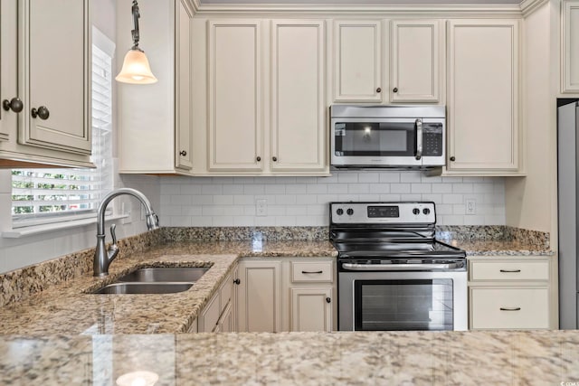 kitchen with stainless steel appliances, a sink, and decorative backsplash