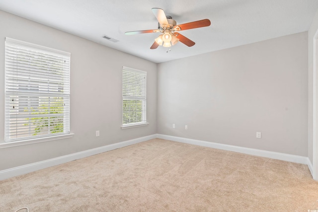 spare room featuring carpet flooring, baseboards, and ceiling fan